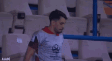 a man wearing a shirt that says champions is standing in a stadium