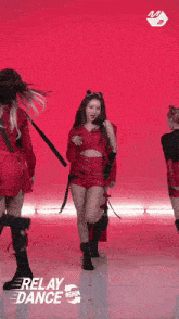 a group of women in red outfits are dancing in front of a red background with relay dance again written on it