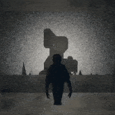 a silhouette of a person standing in front of a large object in the dark .