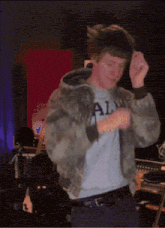 a man wearing a shirt that says ' al ' on it is dancing
