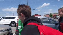 a man in a red jacket is talking to another man