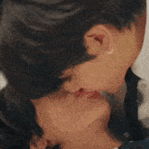a close up of two people kissing with one wearing a hoop earring