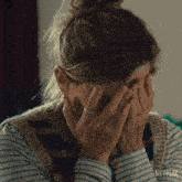 a woman is covering her face with her hands and a netflix logo is visible in the corner