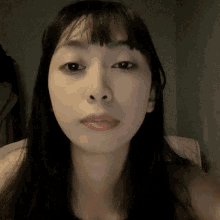 a close up of a woman 's face with long black hair