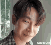 a close up of a young man 's face making a funny face while looking at the camera .