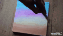 a person is painting on a canvas with the words made in animatica on the bottom right