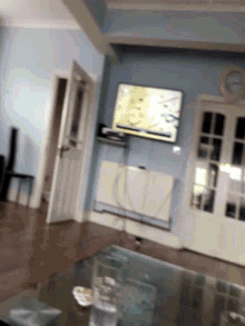 a blurred image of a room with a television and a clock on the wall
