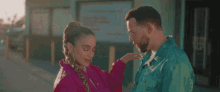 a man and woman are standing next to each other on a street