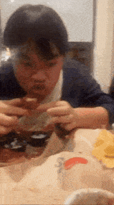 a person sitting at a table eating a piece of food with a mcdonald 's logo in the background