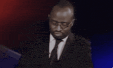 a man in a suit and tie with glasses on