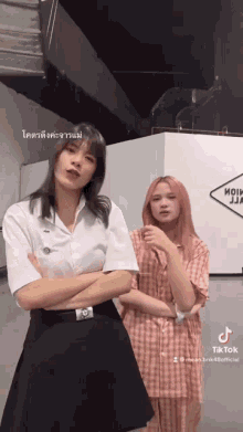 two girls are standing next to each other with their arms crossed
