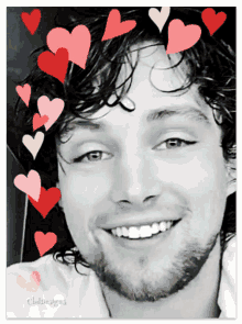 a black and white photo of a smiling man with hearts around his face