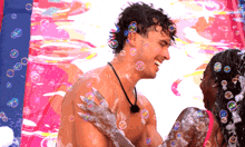 a man and woman are covered in soap bubbles and smiling