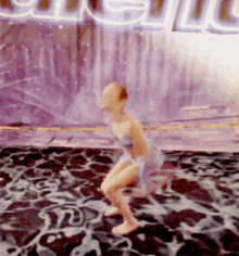 a girl is squatting in front of a sign that says ' pacific ' on it