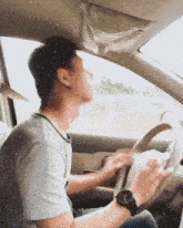 a man wearing a watch is driving a car with his eyes closed