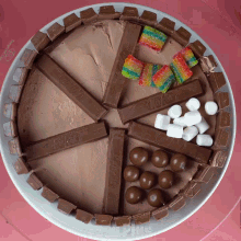 a kitkat cake with candy and marshmallows on a plate