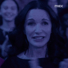 a woman in a dark room with a max logo on the bottom