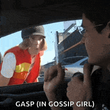 a woman in a red vest is talking to a man in a car and gasp ( in gossip girl