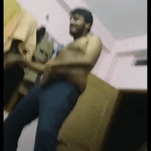 a shirtless man is dancing in a room