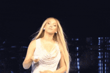 a woman in a white dress is dancing on stage