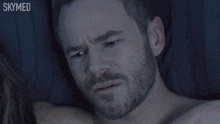 a man with a beard is laying on a bed with the words " are you crying " below him