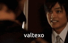 a group of men are standing in a room and the word valtexo is on the screen