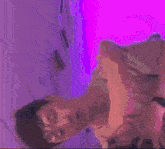 a man in a tank top is laying down with his head down