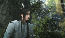 a man in a kimono stands in front of a screen that says as