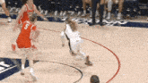 a female basketball player with the number 5 on her jersey is dribbling the ball .