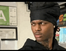 a man wearing a chef 's hat is making a funny face in a restaurant .