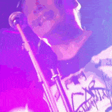 a man playing a trumpet with a shirt that says x on it
