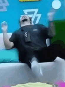 a man is laying on a couch with a ball in his hand .