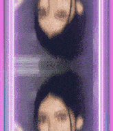 a blurry picture of a woman 's face is surrounded by purple and pink lights