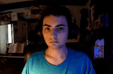 a man wearing headphones looks at the camera with a box of kleenex in front of him