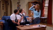 two men and a woman are sitting on a couch talking to each other