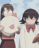 a girl with glasses is holding a pillow with a face on it