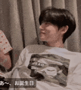 a man wearing a shirt that says " a bathing ape " is smiling