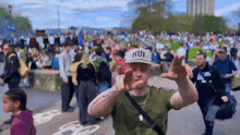 a man wearing a hat that says huf is dancing in front of a crowd
