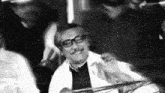 a black and white photo of a man wearing glasses and a mustache