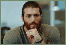 a man with a beard wears a ring on his finger