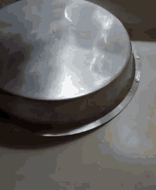 a metal tray is sitting on a white surface with water drops on it