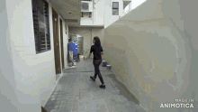a woman is walking down a hallway with the words made in animotica at the bottom