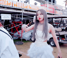 a woman standing in front of a sign that says artist relations golf cart parking only