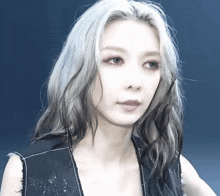 a woman with gray hair is wearing a black top
