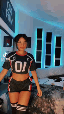 a girl wearing a crop top and shorts with the number 01 on it