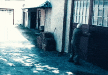 a man is standing in front of a building with a garage door