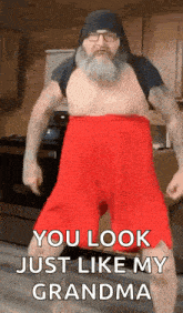 a man with a beard and red shorts is dancing in a kitchen and says `` you look just like my grandma '' .