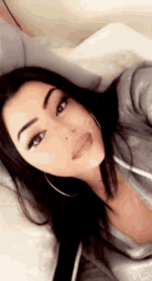 a woman is laying on a bed and taking a selfie .