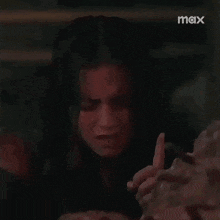 a woman is crying in a dark room while holding a pile of bricks .