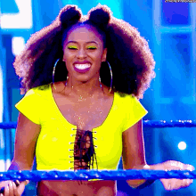 a woman in a yellow top is smiling while holding a rope